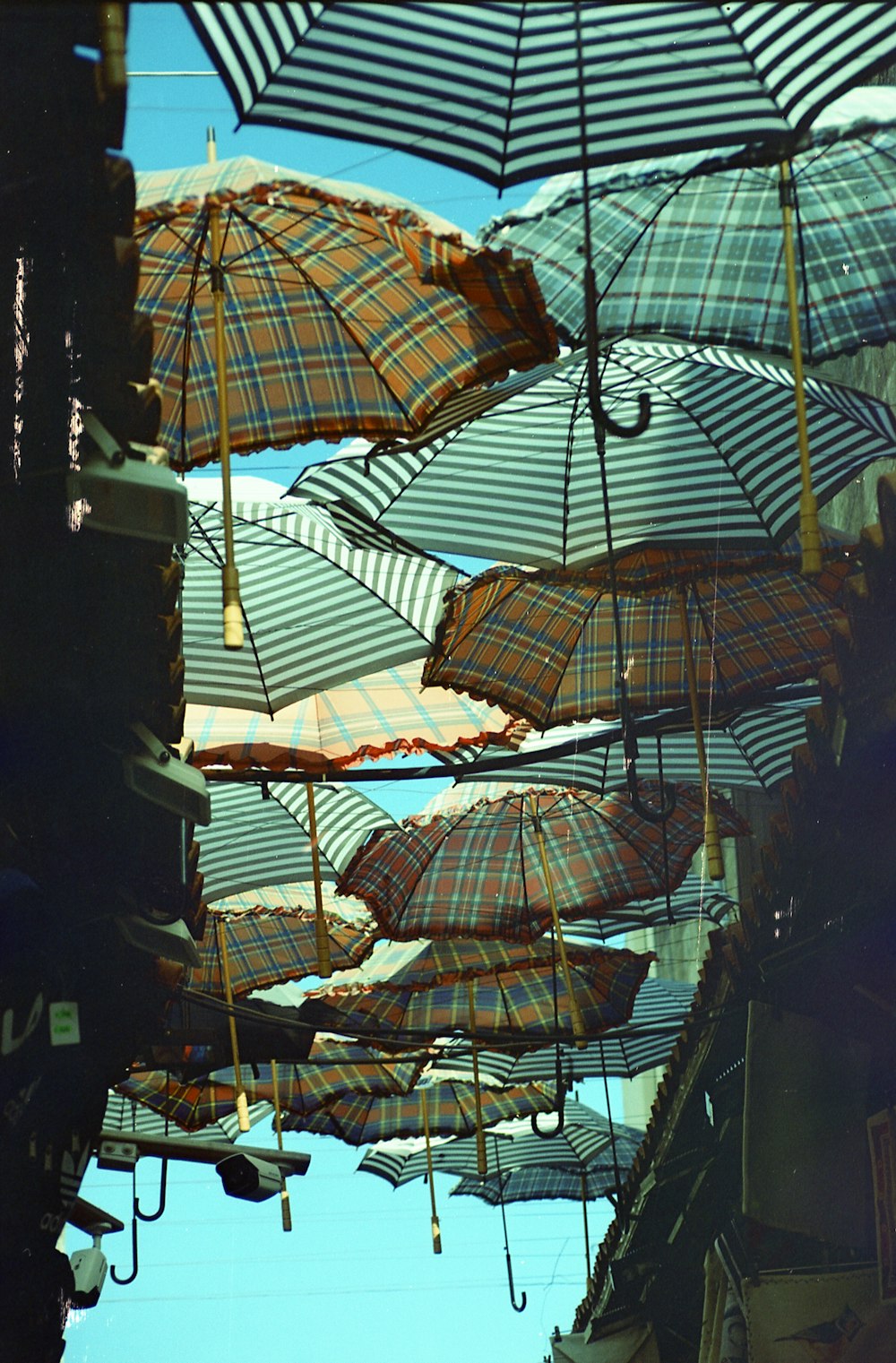 white and brown umbrella hanging on black metal frame