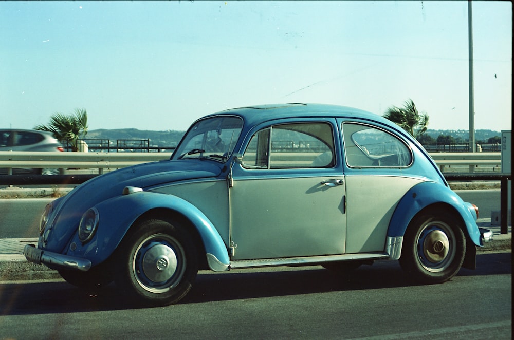 blue volkswagen beetle on road during daytime