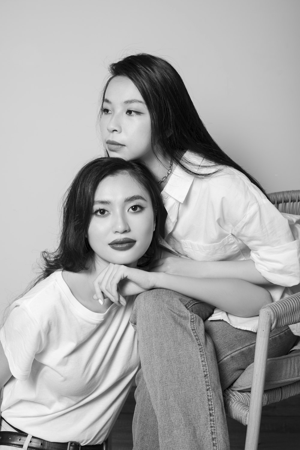 woman in white long sleeve shirt sitting beside girl in white long sleeve shirt