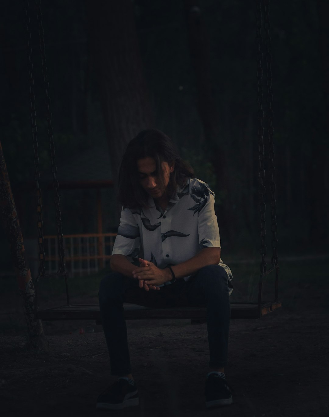 woman in white long sleeve shirt sitting on brown wooden bench