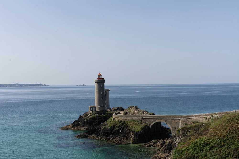 white lighthouse on brown rock formation near sea during daytime