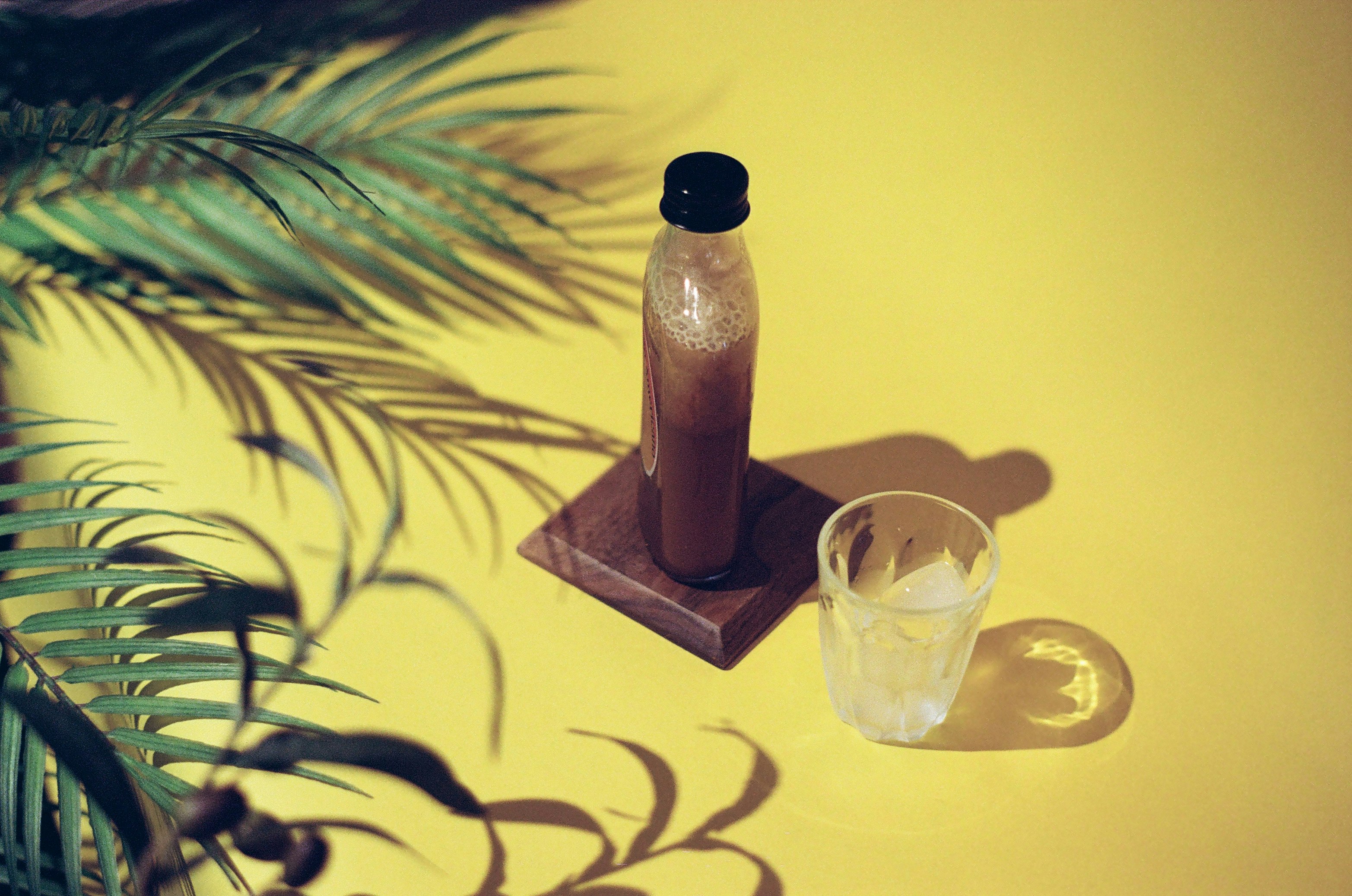 brown glass bottle beside clear drinking glass