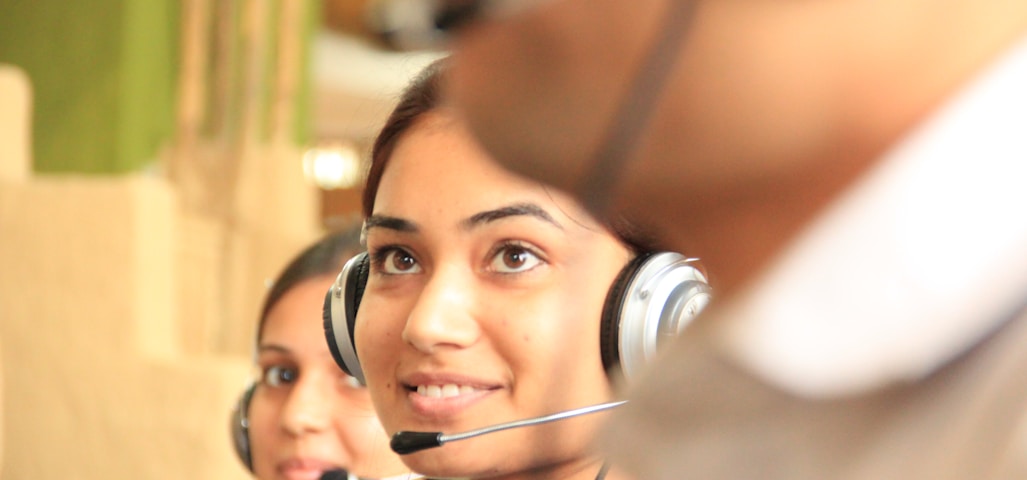 woman in black headphones holding black and silver headphones