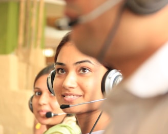 woman in black headphones holding black and silver headphones