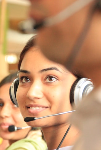 woman in black headphones holding black and silver headphones