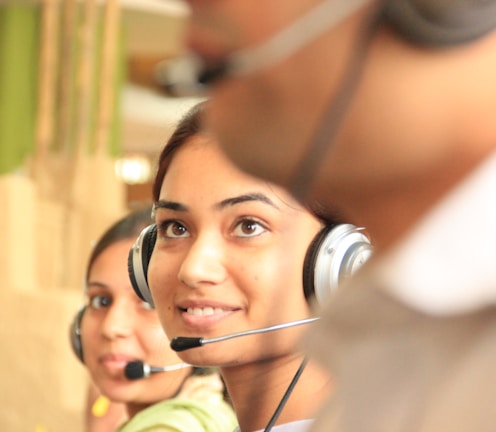 woman in black headphones holding black and silver headphones