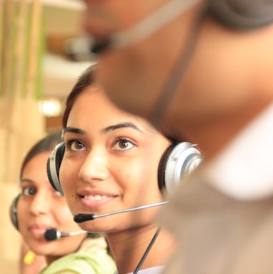 woman in black headphones holding black and silver headphones