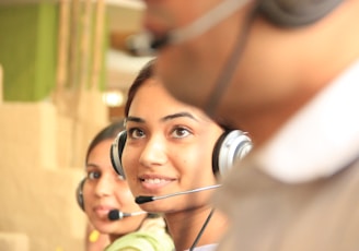 woman in black headphones holding black and silver headphones