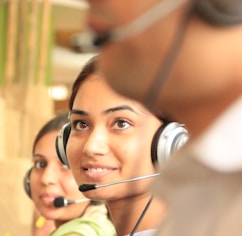 woman in black headphones holding black and silver headphones