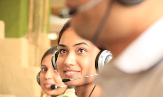 woman in black headphones holding black and silver headphones