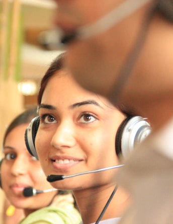 woman in black headphones holding black and silver headphones