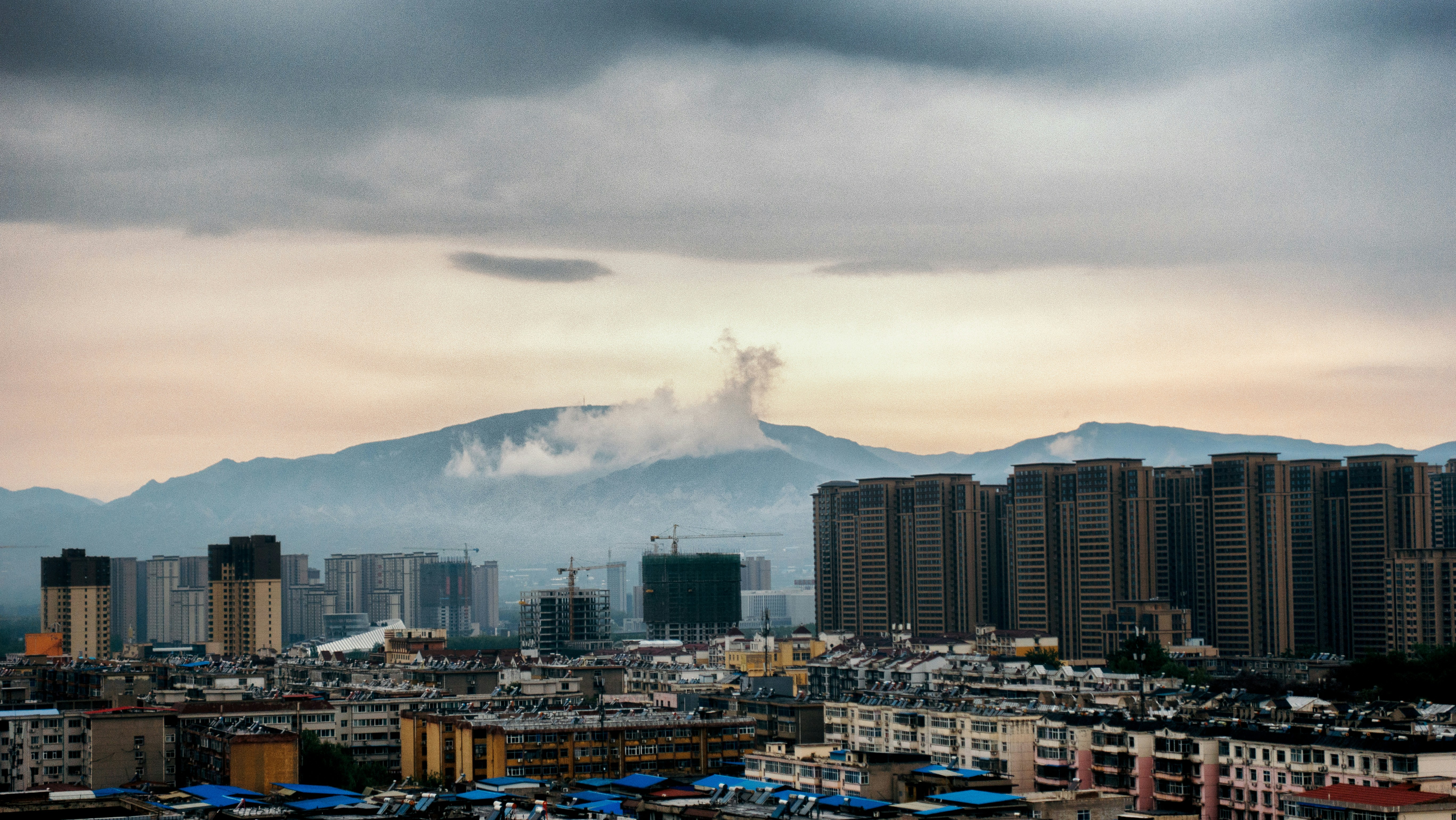 city skyline under white clouds during daytime