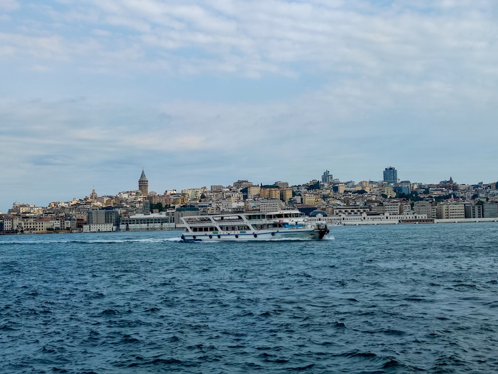 white boat on sea near city buildings during daytime