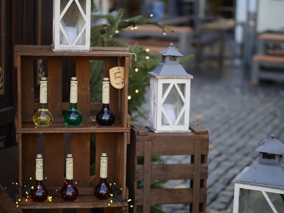 A rustic wooden crate filled with bottles of artisanal Portuguese wine and jars of golden extra virgin olive oil, set against a sunlit vineyard backdrop.
