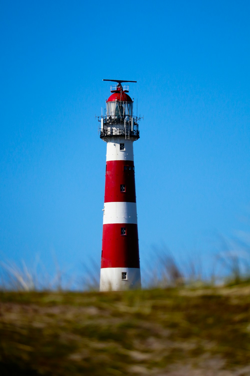 red and white lighthouse under blue sky during daytime