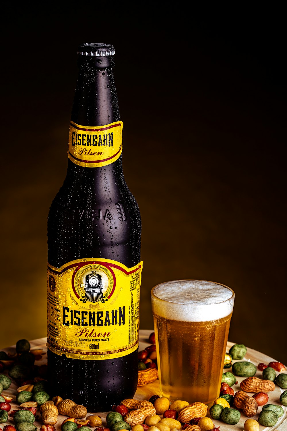 brown glass bottle beside clear drinking glass