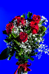 A luxurious funeral wreath featuring deep red roses and satin ribbons, symbolizing premium quality.