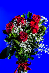 A luxurious funeral wreath featuring deep red roses and satin ribbons, symbolizing premium quality.