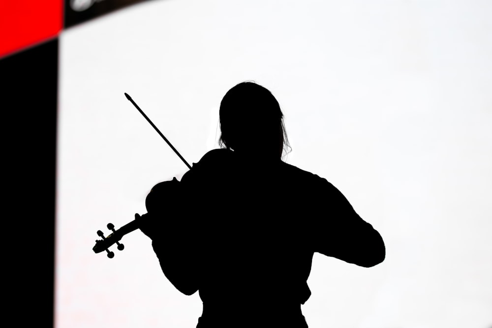 silhouette of woman playing guitar