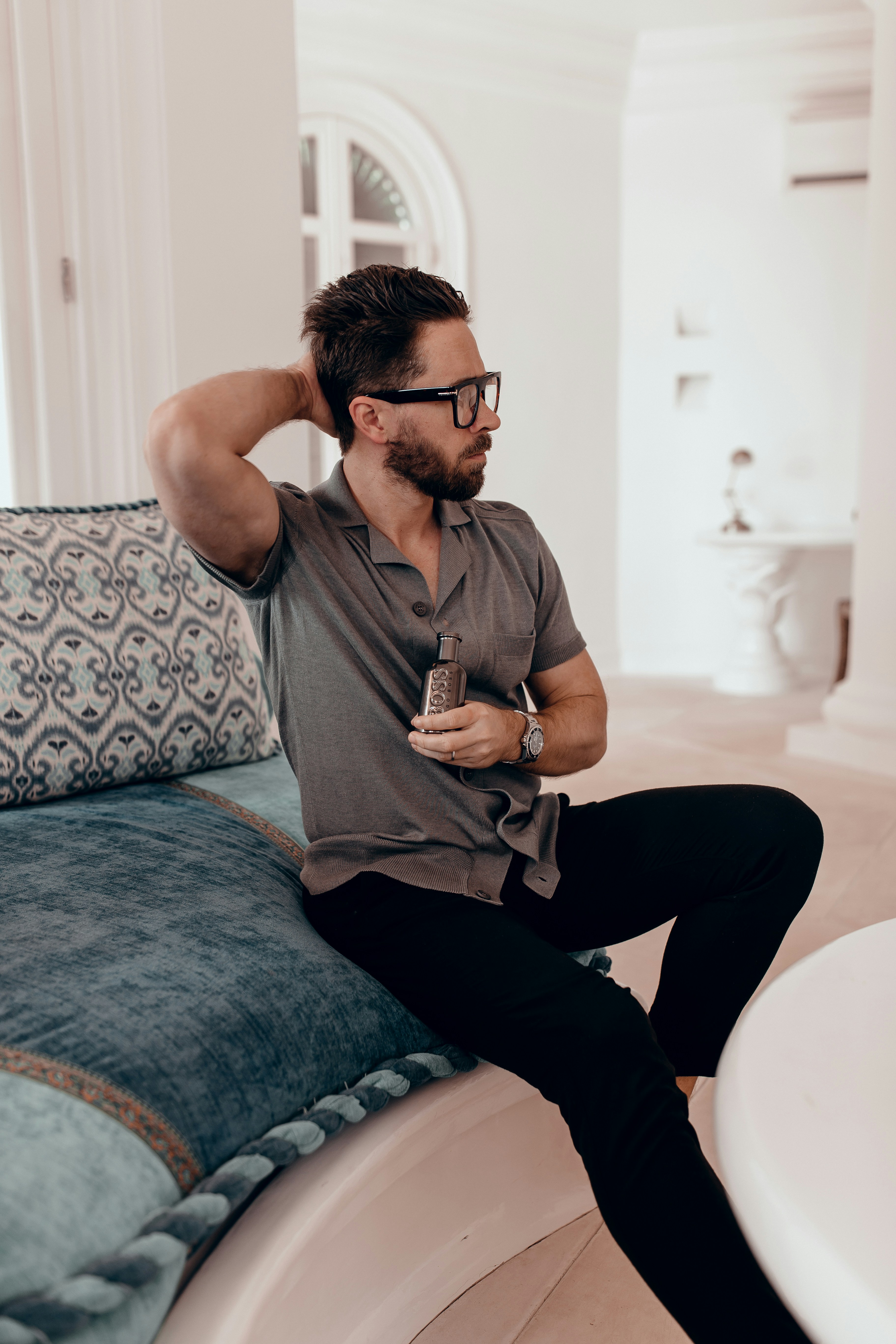 man in gray crew neck t-shirt and black pants sitting on blue and white floral