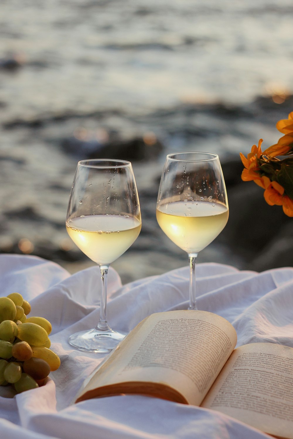 clear wine glass with yellow liquid on white table cloth