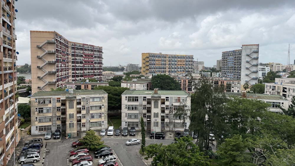 cars parked on parking lot near high rise buildings during daytime