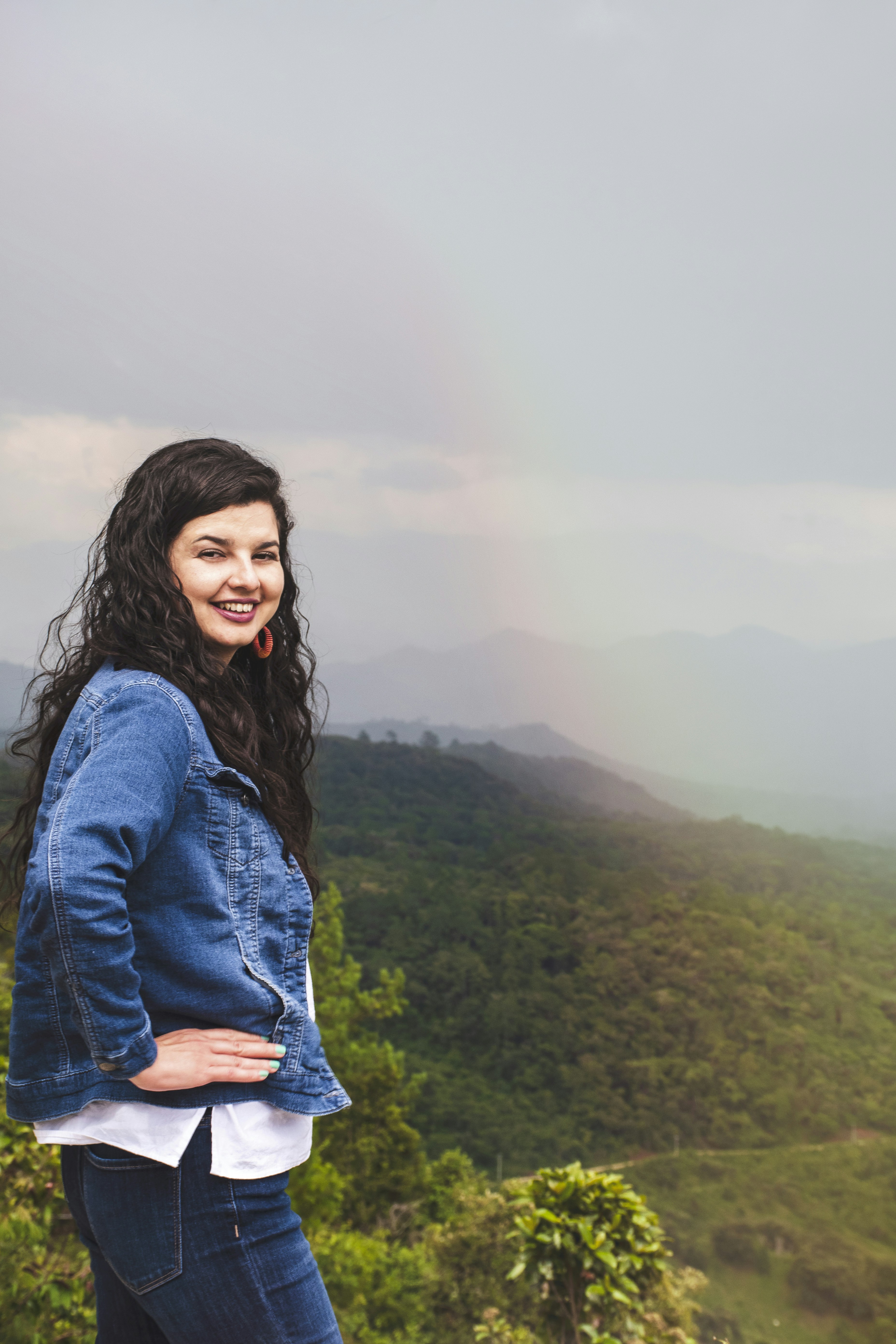 Woman in blue denim jacket standing on top of mountain during daytime ...
