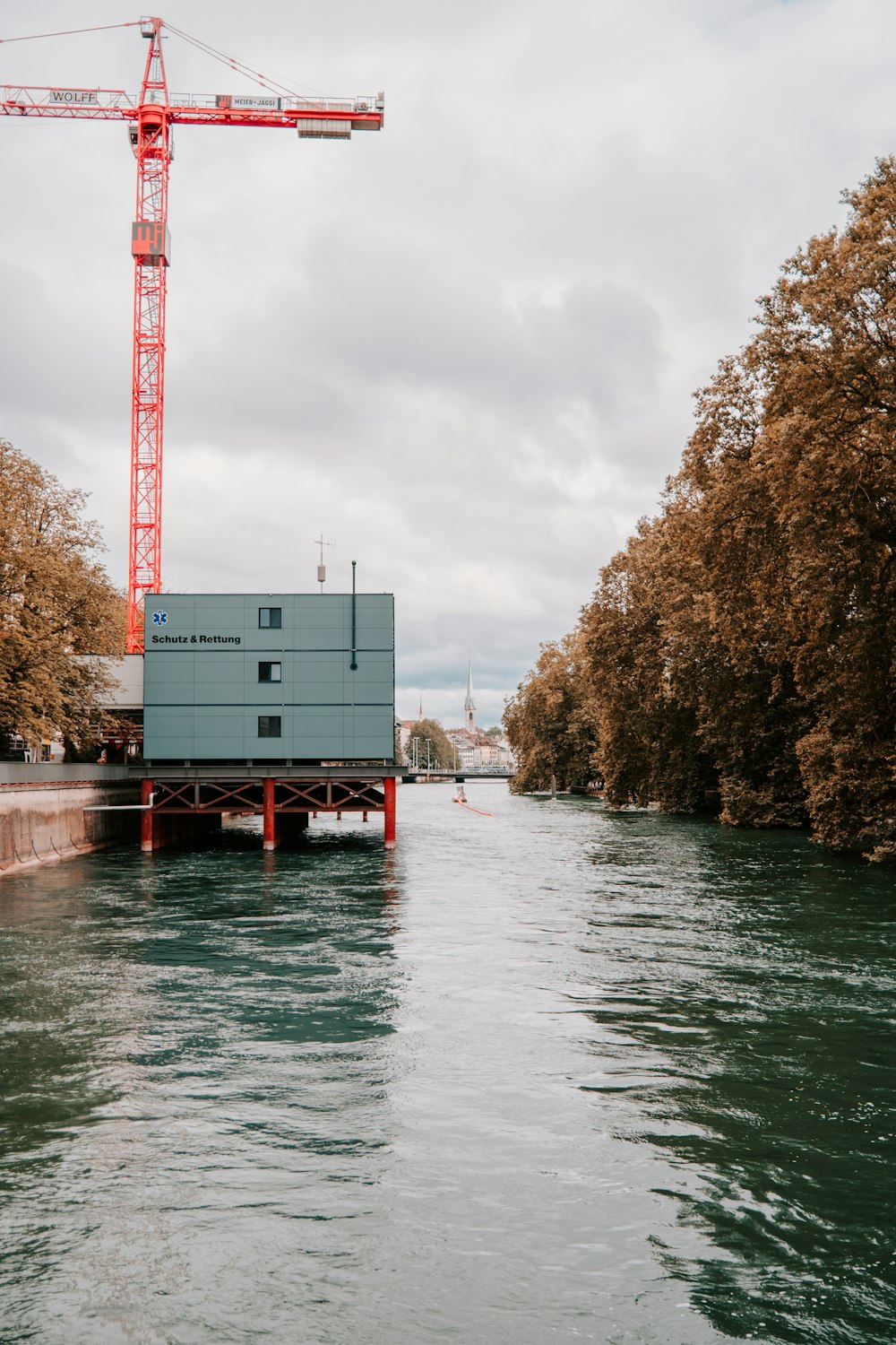 white and red metal tower near body of water during daytime