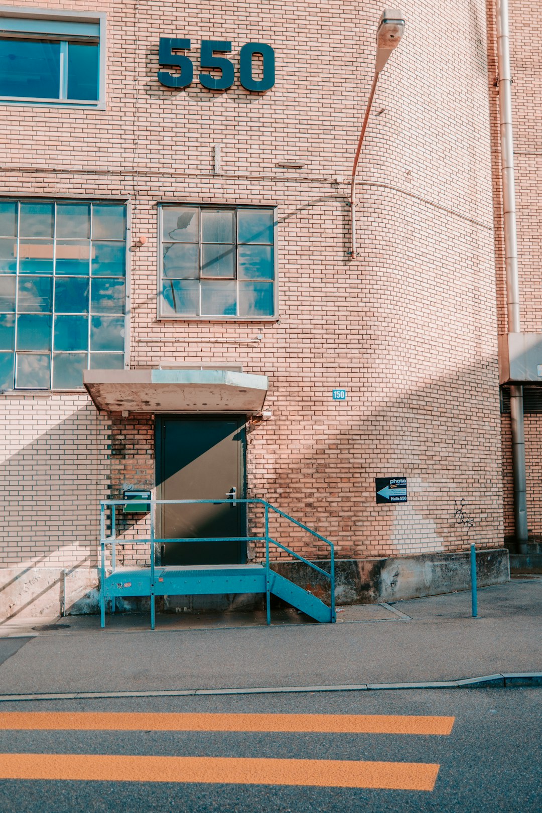 blue metal ladder beside brown brick building