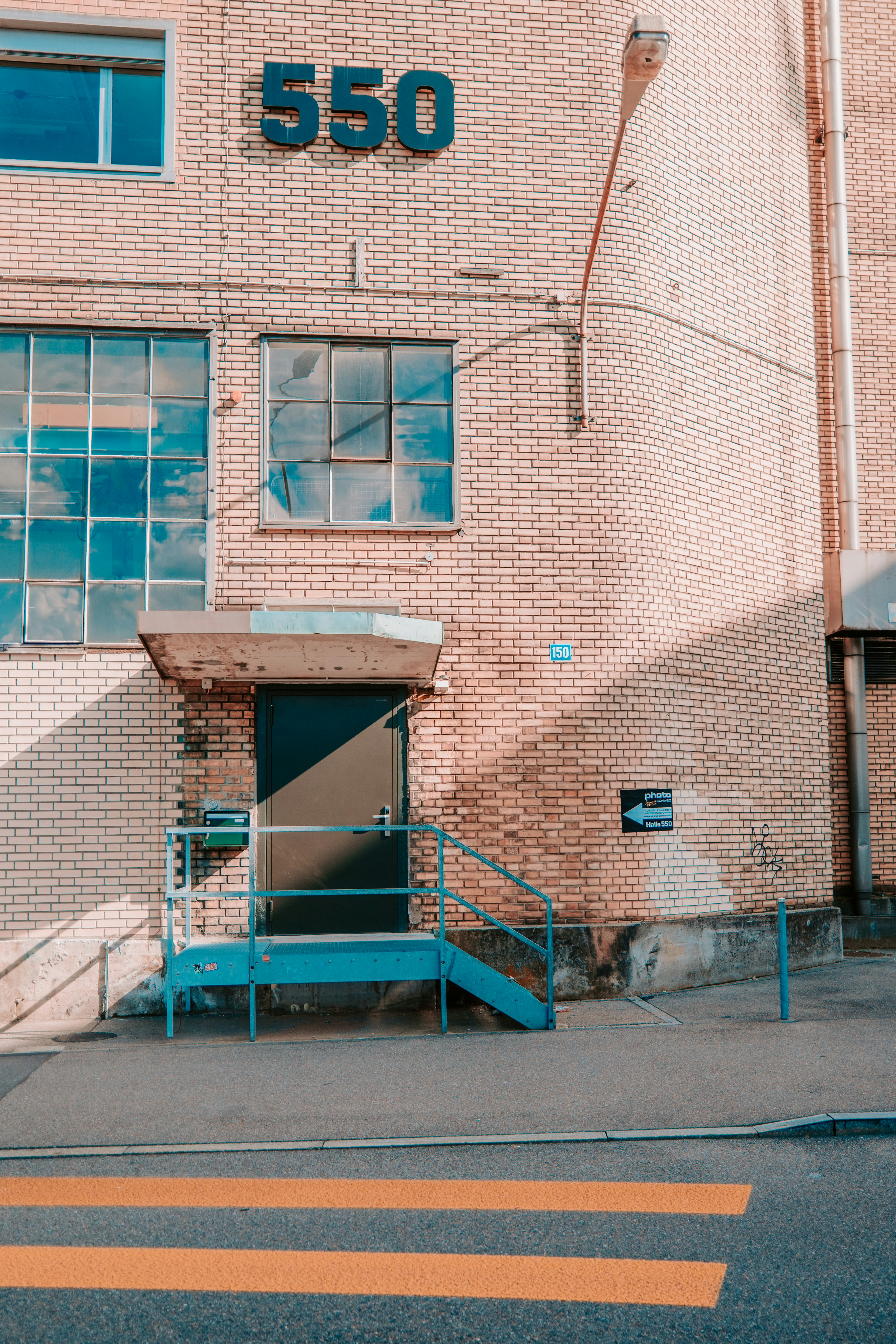 blue metal ladder beside brown brick building