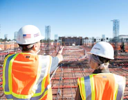 two construction workers in safety vests at site