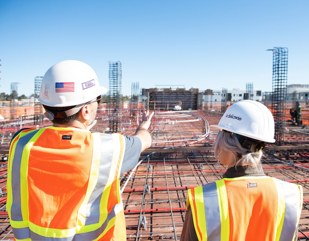 man in white hard hat standing on brown wooden dock during daytime