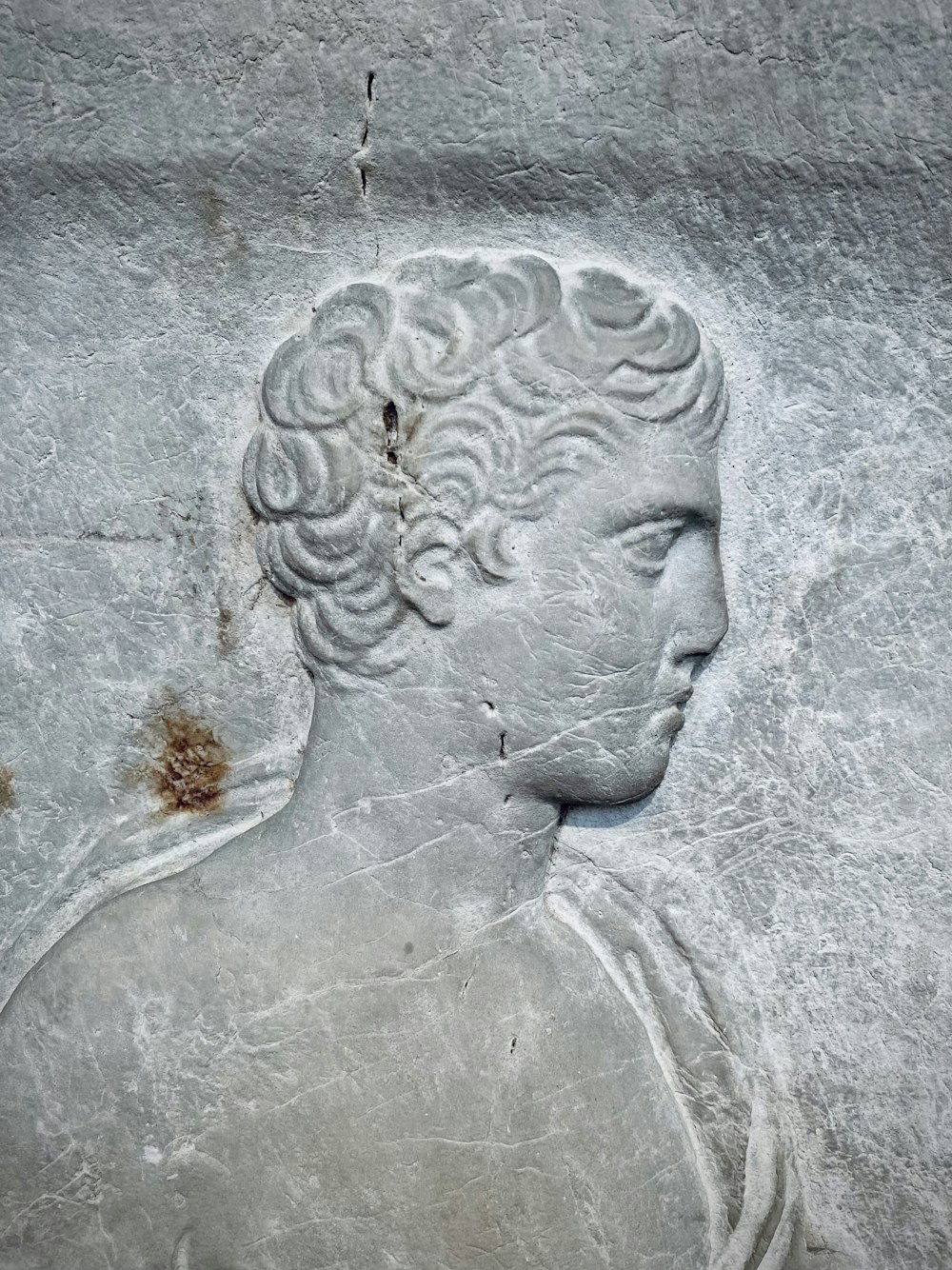 parede de concreto cinza com rosto humano esculpido
