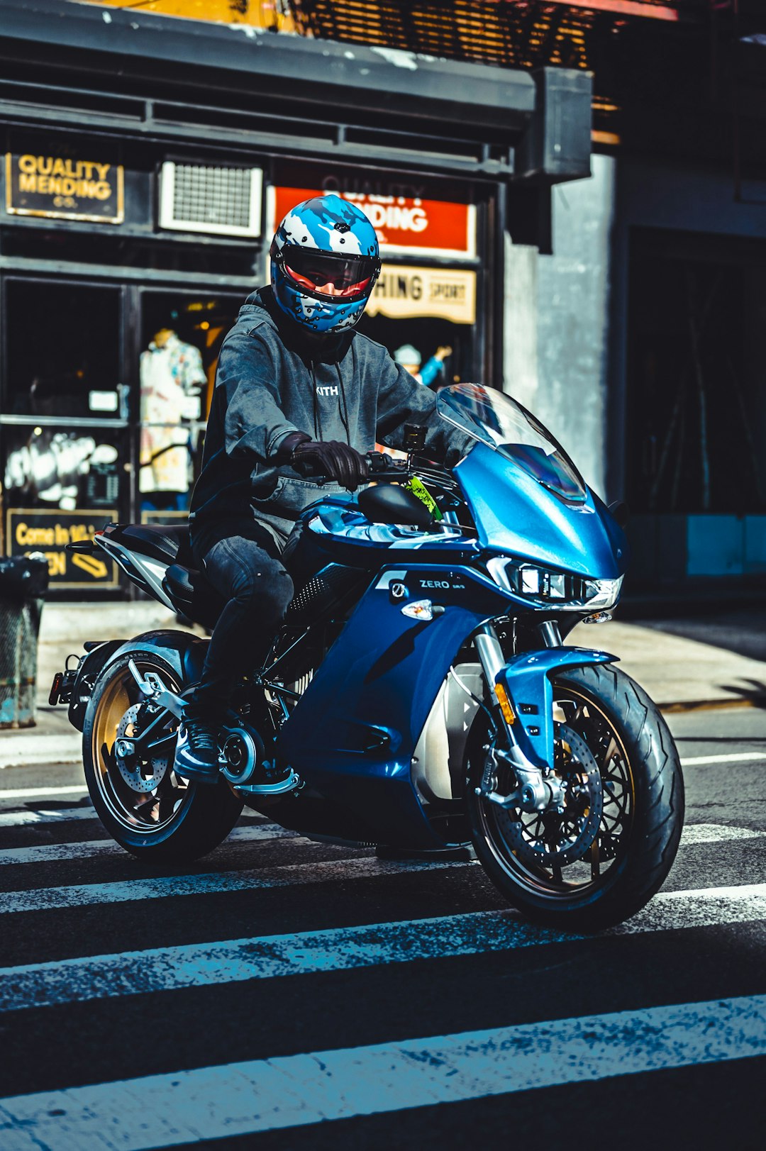 man in black jacket riding blue sports bike