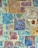 A textured mosaic of stone tiles displaying a variety of shapes and sizes. The tiles have a weathered appearance with a mixture of earthy and blue tones, featuring intricate patterns and natural formations.