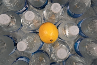 Close-up of three vibrant lemonade bottles in lemon green, lime green, and bright yellow hues on a white background.