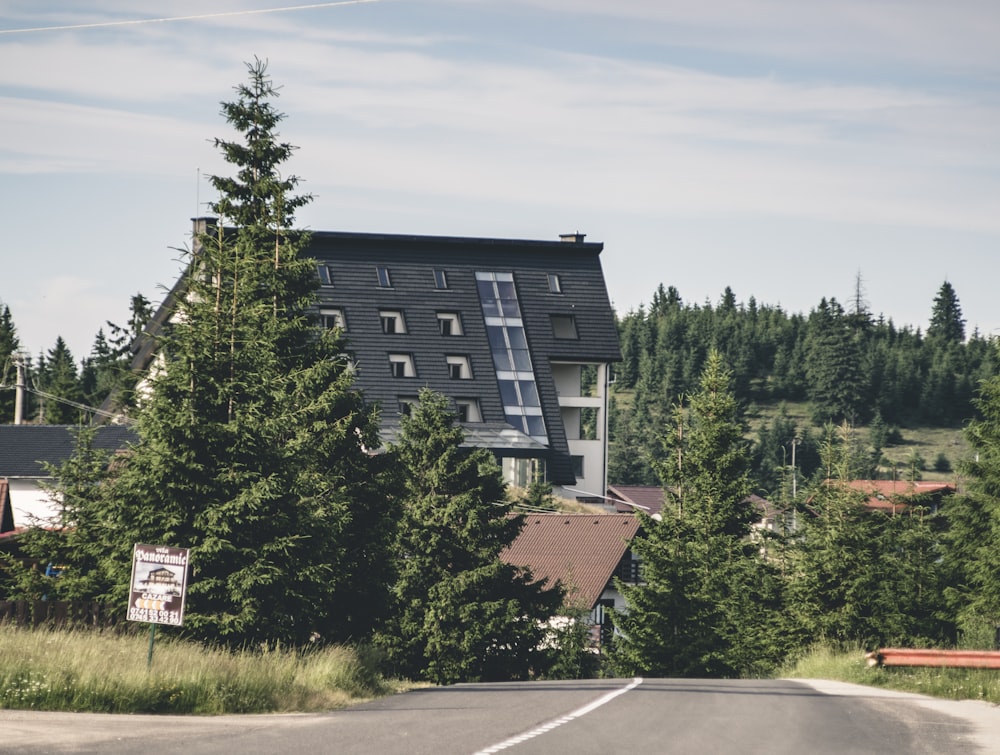 black and white concrete building near green trees under blue sky during daytime