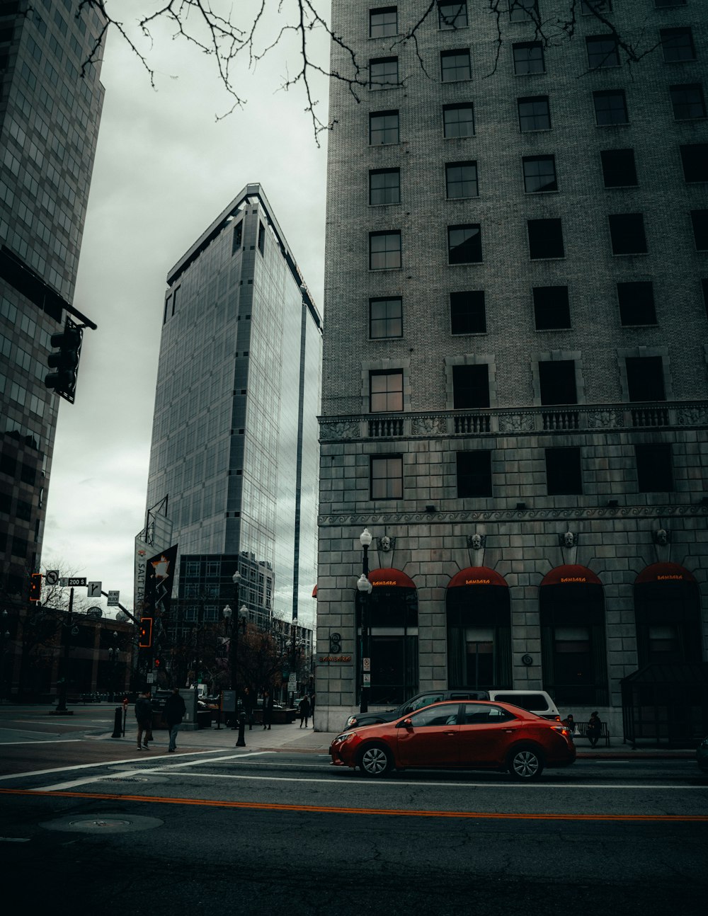 red sedan on road near high rise building during daytime