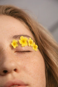 woman with yellow flower on her ear