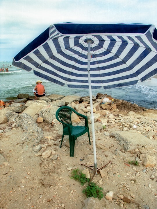 green and white patio umbrella on beach shore during daytime in Durrës Albania