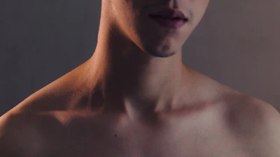 Close-up of a client's jawline before and after contouring treatment under warm, neutral lighting.
