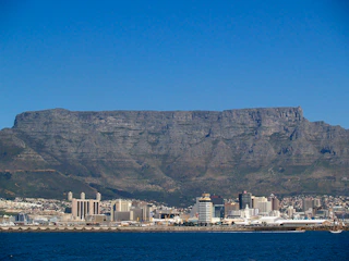 white and brown buildings on brown mountain near body of water during daytime