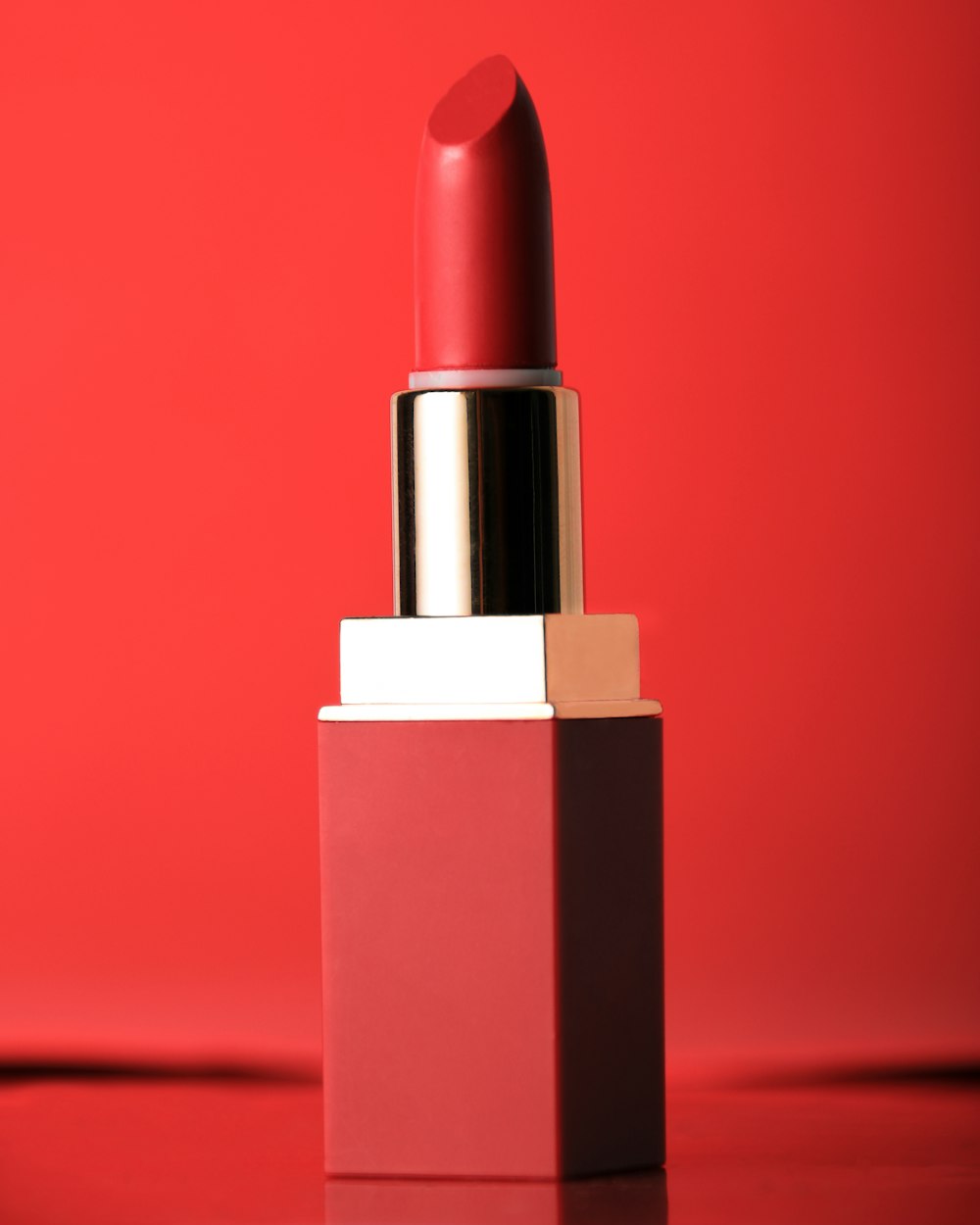 lápiz labial rojo sobre superficie roja