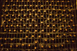 Rustic wooden wine rack filled with assorted Tuscan wine bottles in a cozy cellar.
