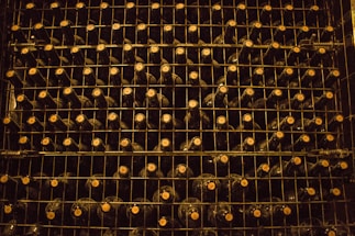 A warmly lit custom wine cellar showcasing handcrafted wooden racks filled with diverse wine bottles.