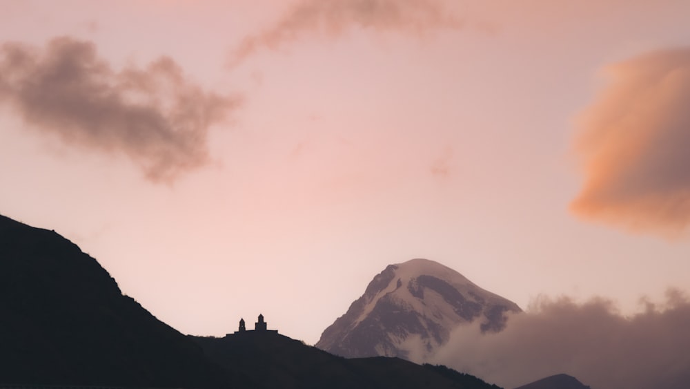 silhouette of mountain under cloudy sky during daytime