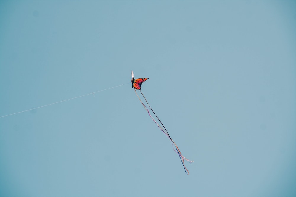 red and white kite flying in the sky