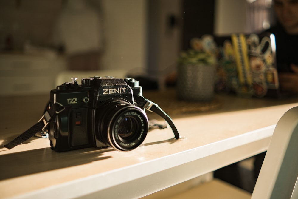 black nikon dslr camera on white table