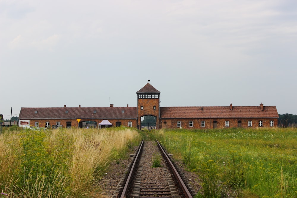 Braunes Betongebäude in der Nähe der Bahnschiene tagsüber