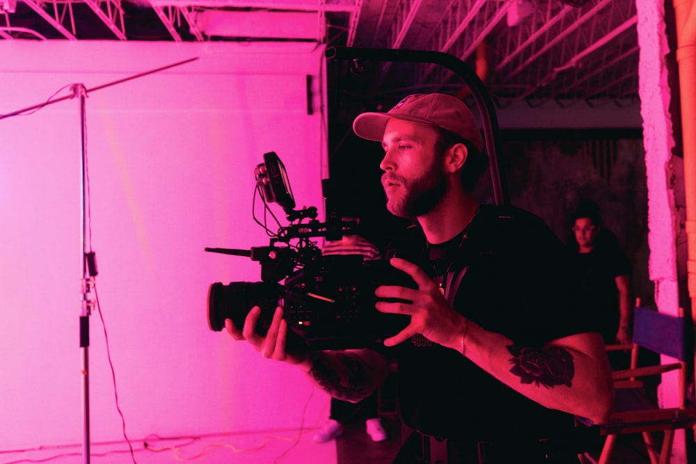 man in black crew neck t-shirt holding black dslr camera